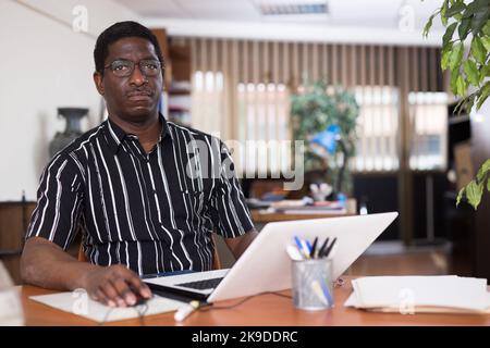Homme d'affaires afro-américain concentré travaillant avec un ordinateur portable Banque D'Images