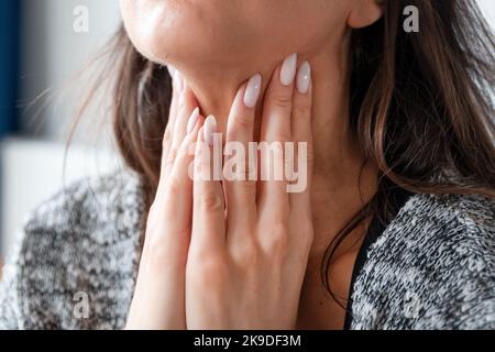 Jeune femme auto-examen glande thyroïde. Hashimoto ou le concept de cancer de la thyroïde Banque D'Images