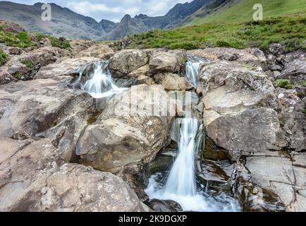 Longue ligne de chutes d'eau et de piscines de montagne rocheuses au pied des montagnes Black Cuillin, site touristique populaire, spectaculaire paysage de Skye, un chemin escarpé Banque D'Images