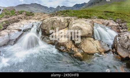 Longue ligne de chutes d'eau et de piscines de montagne rocheuses au pied des montagnes Black Cuillin, site touristique populaire, spectaculaire paysage de Skye, un chemin escarpé Banque D'Images