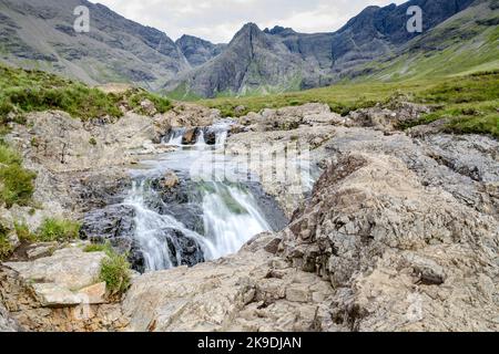 Longue ligne de chutes d'eau et de piscines de montagne rocheuses au pied des montagnes Black Cuillin, site touristique populaire, spectaculaire paysage de Skye, un chemin escarpé Banque D'Images