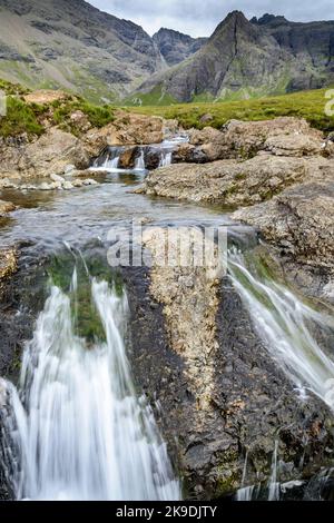 Longue ligne de chutes d'eau et de piscines de montagne rocheuses au pied des montagnes Black Cuillin, site touristique populaire, spectaculaire paysage de Skye, un chemin escarpé Banque D'Images