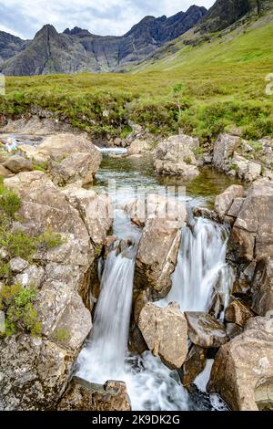 Longue ligne de chutes d'eau et de piscines de montagne rocheuses au pied des montagnes Black Cuillin, site touristique populaire, spectaculaire paysage de Skye, un chemin escarpé Banque D'Images