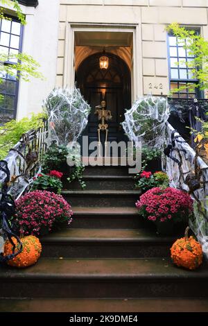 NEW YORK, NEW YORK - 25 octobre 2022 : les toiles d'araignée, les citrouilles mènent à un squelette debout à la porte d'une maison à New York, New York, le mardi 25 octobre 2022. (Photo : Gordon Donovan) Banque D'Images