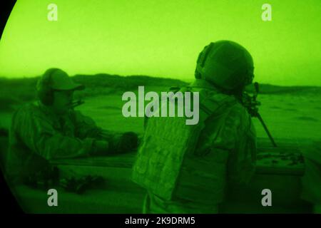 Sergent d'état-major de la Force aérienne des États-Unis Cody Young, instructeur de cours de mitrailleuse légère, centre, donne des instructions à Airman First Class Devonte Wartell sur l'utilisation appropriée d'un oscilloscope thermique monté sur une mitrailleuse légère M249 avant un exercice nocturne de feu en direct à la réserve d'entraînement militaire de la base conjointe San Antonio-Camp Bullis, Texas, le 5 octobre 2022. Le LMGC de deux semaines se termine par une familiarisation avec les armes à feu vivant de trois jours dans de multiples conditions conçues pour préparer les étudiants aux exigences de la première journée de mission dans les futurs lieux où cette formation n'est pas disponible. (É.-U. Photo de la Force aérienne par Brian Boisv Banque D'Images