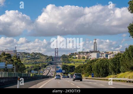 En voiture à Lisbonne, Portugal sur l'autoroute A2, le quartier d'Almada, le pont Ponte 25 de Abril et la statue du Christ Roi en arrière-plan Banque D'Images