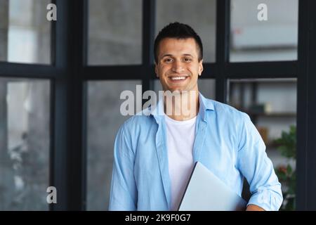 Portrait d'un jeune homme d'affaires ou d'un entrepreneur prospère debout dans un bureau moderne Banque D'Images