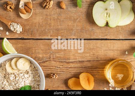 Table de nourriture pour le petit déjeuner. Ingrédients pour cuisiner des flocons d'avoine sains pour le petit déjeuner, fruits secs et frais, miel et noix vue du dessus Banque D'Images