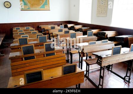 Ancienne salle de classe historique avec bureaux et tableaux en bois Banque D'Images