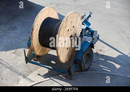 Concept de fourniture d'électricité pour les projets de construction. Bobine en bois avec câble d'alimentation. Banque D'Images