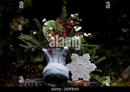 Une chaussure grise avec branches en sapin et flocons de neige en béton Banque D'Images
