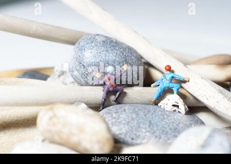 Miniature d'hommes et de biscuit montagne, une série de photographies utilisant des personnes miniatures, des biscuits à la confiture et des cailloux montrant un monde miniature d'images. Banque D'Images