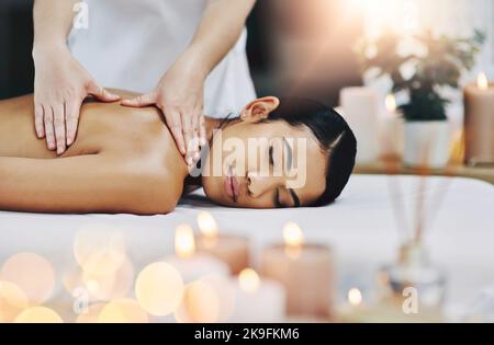Se débarrasser de toute la tension. Une jeune femme détendue et gaie se fait masser à l'intérieur d'un spa. Banque D'Images