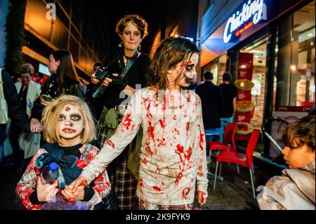 Arnhem, pays-Bas. 27th octobre 2022. Les enfants ont vu prétendre être des zombies pendant la parade. Cette année encore, les zombies ont été autorisés à s'échelonner à travers la ville intérieure d'Arnhem à la recherche de cerveaux frais. La promenade a commencé au concert de musique 'Willemeen', où les artistes de maquillage ont créé leur maquillage zombie. La Zombie Walk a lieu chaque année le jeudi soir avant Halloween, parce que c'est le seul jour de la semaine que les magasins sont ouverts jusqu'à tard dans la soirée, de sorte que les gens peuvent apprécier les magasins et les fracas des zombies. Crédit : SOPA Images Limited/Alamy Live News Banque D'Images