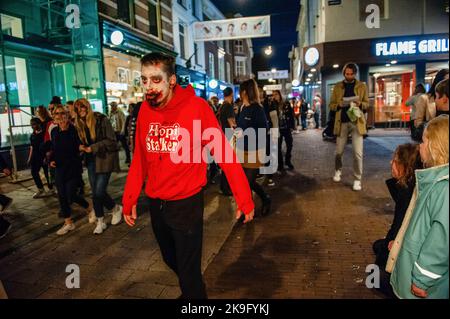 Arnhem, pays-Bas. 27th octobre 2022. Un zombie marche dans les rues tout en effrayant les gens. Cette année encore, les zombies ont été autorisés à s'échelonner à travers la ville intérieure d'Arnhem à la recherche de cerveaux frais. La promenade a commencé au concert de musique 'Willemeen', où les artistes de maquillage ont créé leur maquillage zombie. La Zombie Walk a lieu chaque année le jeudi soir avant Halloween, parce que c'est le seul jour de la semaine que les magasins sont ouverts jusqu'à tard dans la soirée, de sorte que les gens peuvent apprécier les magasins et les fracas des zombies. Crédit : SOPA Images Limited/Alamy Live News Banque D'Images