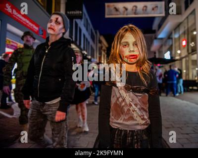 Arnhem, pays-Bas. 27th octobre 2022. Une petite fille a vu porter un maquillage zombie. Cette année encore, les zombies ont été autorisés à s'échelonner à travers la ville intérieure d'Arnhem à la recherche de cerveaux frais. La promenade a commencé au concert de musique 'Willemeen', où les artistes de maquillage ont créé leur maquillage zombie. La Zombie Walk a lieu chaque année le jeudi soir avant Halloween, parce que c'est le seul jour de la semaine que les magasins sont ouverts jusqu'à tard dans la soirée, de sorte que les gens peuvent apprécier les magasins et les fracas des zombies. Crédit : SOPA Images Limited/Alamy Live News Banque D'Images