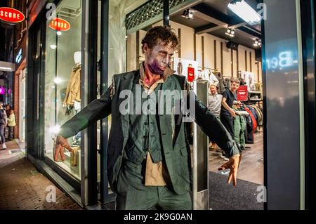 Arnhem, pays-Bas. 27th octobre 2022. Un zombie quitte un magasin de vêtements. Cette année encore, les zombies ont été autorisés à s'échelonner à travers la ville intérieure d'Arnhem à la recherche de cerveaux frais. La promenade a commencé au concert de musique 'Willemeen', où les artistes de maquillage ont créé leur maquillage zombie. La Zombie Walk a lieu chaque année le jeudi soir avant Halloween, parce que c'est le seul jour de la semaine que les magasins sont ouverts jusqu'à tard dans la soirée, de sorte que les gens peuvent apprécier les magasins et les fracas des zombies. (Photo par Ana Fernandez/SOPA Images/Sipa USA) Credit: SIPA USA/Alay Live News Banque D'Images