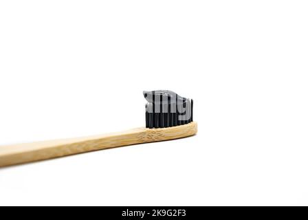 Dentifrice blanchissant au charbon noir sur brosse à dents en bambou, gros plan. Produit écologique naturel pour l'hygiène dentaire. Banque D'Images