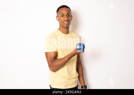 Un jeune africain américain utilisant des haltères, isolé sur fond blanc. Banque D'Images