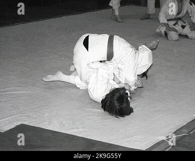 1970s, historique, à l'intérieur, sur un tapis, deux filles en compétition dans le sport du judo, une activité physique qui implique deux personnes luttant et essayant de se jeter à la terre. Judo est un mot japonais signifiant « art de la douceur » et dérive de l'ancien art martial japonais du jujitsu. Banque D'Images