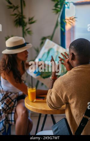 Les amis multiethniques n'ont pas trouvé la position sur la carte. L'homme essaie de l'expliquer où il devrait être Banque D'Images