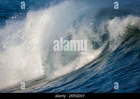 La vague bleue de l'océan Atlantique se brise, la pulvérisation vole sur la rive d'Hermanus. Whale Coast, Overberg, Western Cape, Afrique du Sud. Banque D'Images