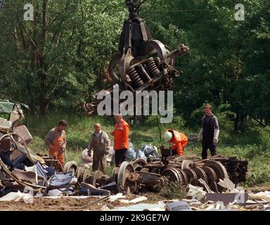 Mitglieder des Bergungsteams tragen am 5.6.1998 in Eschede (Kreis celle) Räder und Achsen des verunglückten ICE zusammen. Der Intercity-Express 'Wilhelm Conrad Röntgen' von München nach Hamburg war am 3.6.1998 in dem Heideort entgleist und gegen eine Brücke geprallt, die dalaufhin einstürzte. BEI dem größten Eisenbahnunglück in der Geschichte der Bundesrepublik kamen 102 Menschen ums Leben. Vermutet wird, daß ein gebrochener Radreifen am ersten Wagon des ICE 884 den Zug entsleisen ließ. [dpabilderarchiv] Banque D'Images