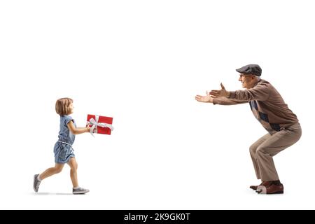 Photo pleine longueur d'une petite fille qui court vers un homme âgé et qui porte un présent isolé sur fond blanc Banque D'Images