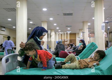 Bebnin, Liban. 28th octobre 2022. Une mère syrienne est assise près de son fils de trois ans, victime d'une épidémie de choléra, dans un hôpital de campagne du village libanais de Bebnin, au nord du pays. Les réfugiés syriens dans les camps de déplacement sont victimes d'une épidémie de choléra au Liban, déjà victimes d'un effondrement économique qui a réduit l'accès à l'eau potable et aux hôpitaux sous pression. Credit: Marwan Naamani/dpa/Alamy Live News Banque D'Images