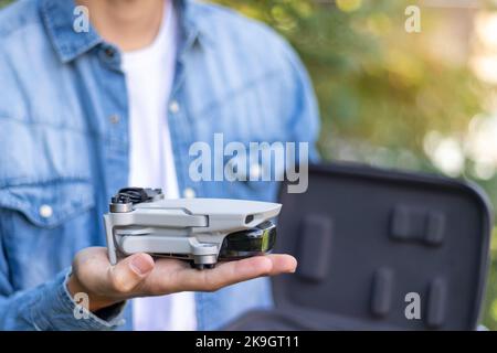 Mise au point sélective vue rapprochée d'un jouet télécommandé d'hélicoptère plié reposant sur les mains d'un garçon méconnaissable Banque D'Images