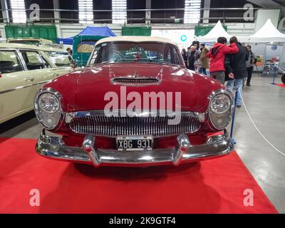 Vieille berline rouge 1959 Kaiser Carabela quatre portes sur le tapis rouge. Salle d'exposition. Vue avant. Chromies. Calandre. Salon de la voiture classique Banque D'Images