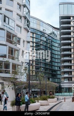 Les gens parlent au téléphone et se promondent dans la nouvelle rue piétonne de Londres, Electric Boulevard à Prospect Park, Battersea Power Station. Banque D'Images