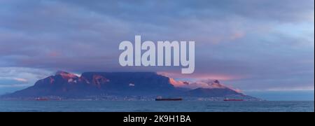 Vue iconique sur Table Bay de Table Mountain et Cape Town lors d'une journée nuageux au coucher du soleil depuis Bloubergstrand dans le Cap occidental. Afrique du Sud. Banque D'Images