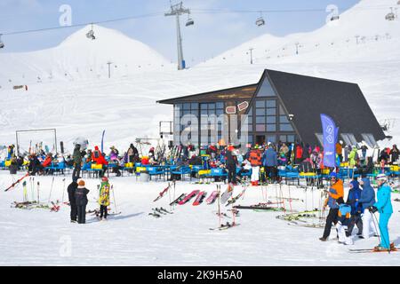 Gudauri, Géorgie - 25th mars 2022 : deux skieurs de patrouille de police s'assoient et font monter les pieds sur les remontées mécaniques de la station de ski de Gudauri. Aide à la sécurité et aux urgences Banque D'Images