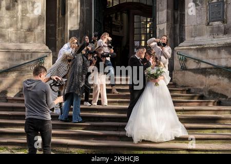 Lviv, Ukraine - 28 octobre 2022: Master class de photographie de mariage. Charmant jeune couple debout dans les vieux escaliers de l'église baroque. Banque D'Images