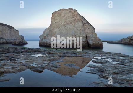 Une scène côtière à couper le souffle avec l'imposant Shark fin Rock se levant de l'océan à Shark fin Cove, Davenport, Californie, au coucher du soleil. Banque D'Images