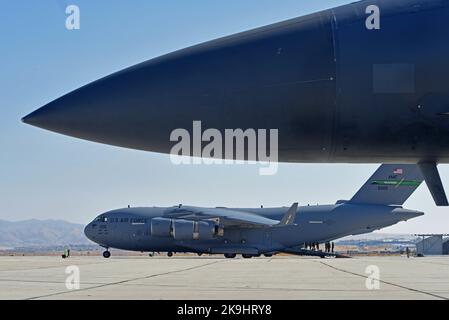 Des aviateurs américains avec l'aile 62D Airlift se tiennent sur la rampe d'un avion C-17 Globemaster III tout en observant les opérations spéciales de ravitaillement d'un avion F-15E Strike Eagle depuis l'aile 366th Fighter, la base aérienne de Mountain Home, Idaho, pendant l'exercice Rainier War 22B à Gowen Field, Boise, Idaho, 20 octobre 2022. L'exercice Rainier War est un exercice majeur pour l'aile du transport aérien de 62D, y compris de multiples actifs de transport aérien et des partenaires communs. (É.-U. Photo de la Force aérienne par le sergent d'état-major. Zoe Thacker) Banque D'Images