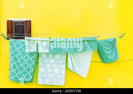 Le mur avec la fenêtre et le linge de lit séchant sur une ligne sur l'île de Burano en Italie Banque D'Images