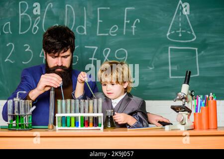 La persévérance paye. Expérience chimique. Symptômes du TDAH à l'école. Programme scolaire. Garçon d'école mignon enfant expérimentant avec des liquides Banque D'Images