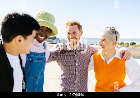 Quatre jeunes amis multiraciaux s'amusant ensemble en plein air Banque D'Images