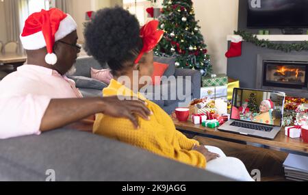 Couple afro-américain senior ayant un appel vidéo de noël avec femme biracial senior Banque D'Images