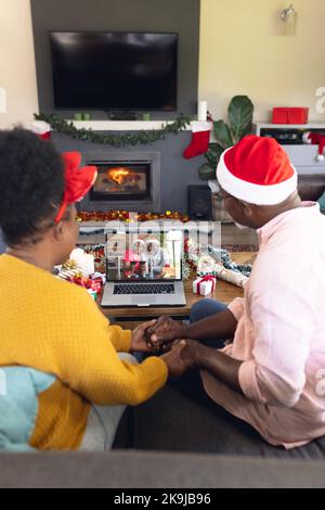 Couple afro-américain senior ayant un appel vidéo de noël avec un couple afro-américain senior Banque D'Images
