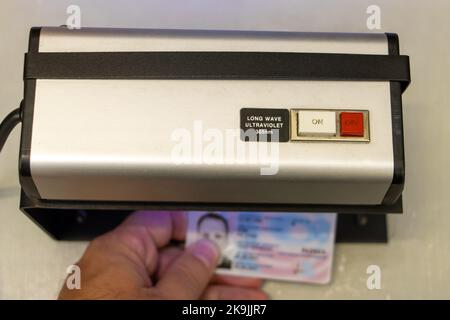 Vérification de la validité d'un document d'identification personnel sous lumière ultraviolette Banque D'Images