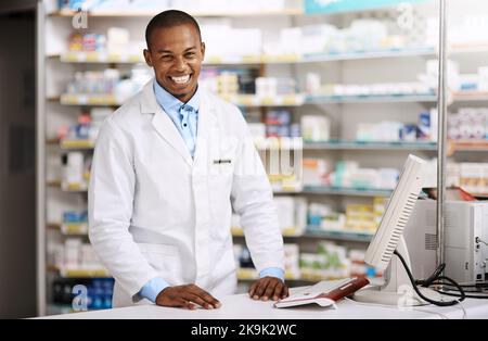 Tout ce que je peux vous aider. Portrait d'un jeune pharmacien travaillant dans un chimiste. Banque D'Images