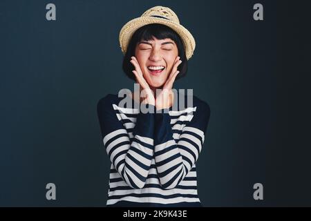 Je suis tellement enthousiaste et je ne peux pas le cacher. Photo en studio d'une jeune femme attrayante sur fond sombre. Banque D'Images