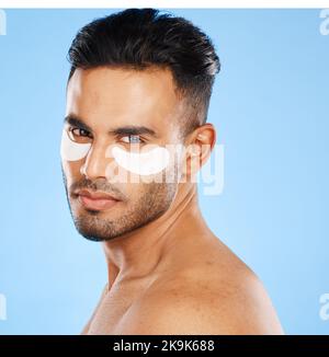 Les taches oculaires, les soins de la peau et le portrait d'un homme debout en studio faisant une routine de beauté cosmétique. Autosoins, modèle sain et masculin faisant le traitement du visage Banque D'Images