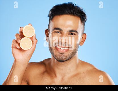 Santé, citron et soin de la peau pour l'homme avec des agrumes pour le visage, la vitamine c et le bien-être avec un sourire sur fond bleu. Dermatologie, beauté et Banque D'Images