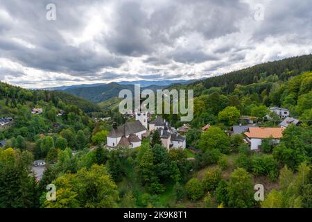 Spania Dolina, Slovaquie - 28 septembre 2022 : vue sur le village et l'église catholique romaine de Spania Dolina avec forêt verte d'été Banque D'Images