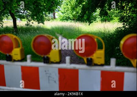 Hambourg, Allemagne. 11th juin 2022. Une barrière de chantier se trouve devant un sentier dans un pré vert sous les arbres de Jenischpark. Credit: Jonas Walzberg/dpa/Alay Live News Banque D'Images