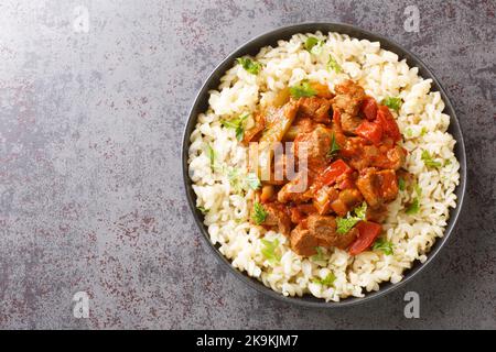 Porkolt est un délicieux ragoût de viande hongrois cuit dans une sauce aux oignons de tomate paprika savoureuse, servi avec des nouilles aux œufs sur l'assiette. Haut horizontal Banque D'Images